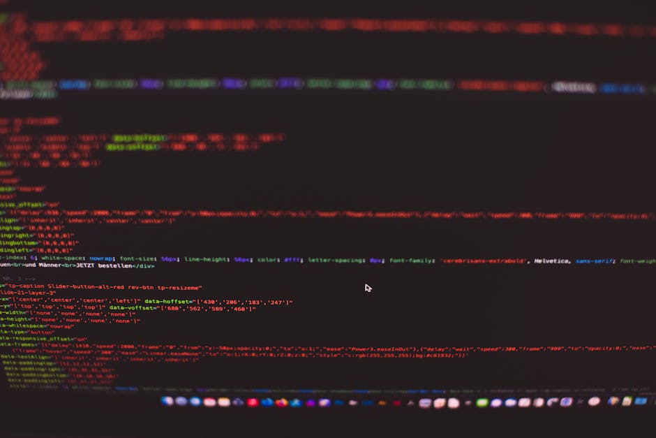A close-up image of a computer screen displaying colorful lines of code, including HTML and CSS syntax, with various tags and attributes visible. The background is dark, and the code is highlighted in