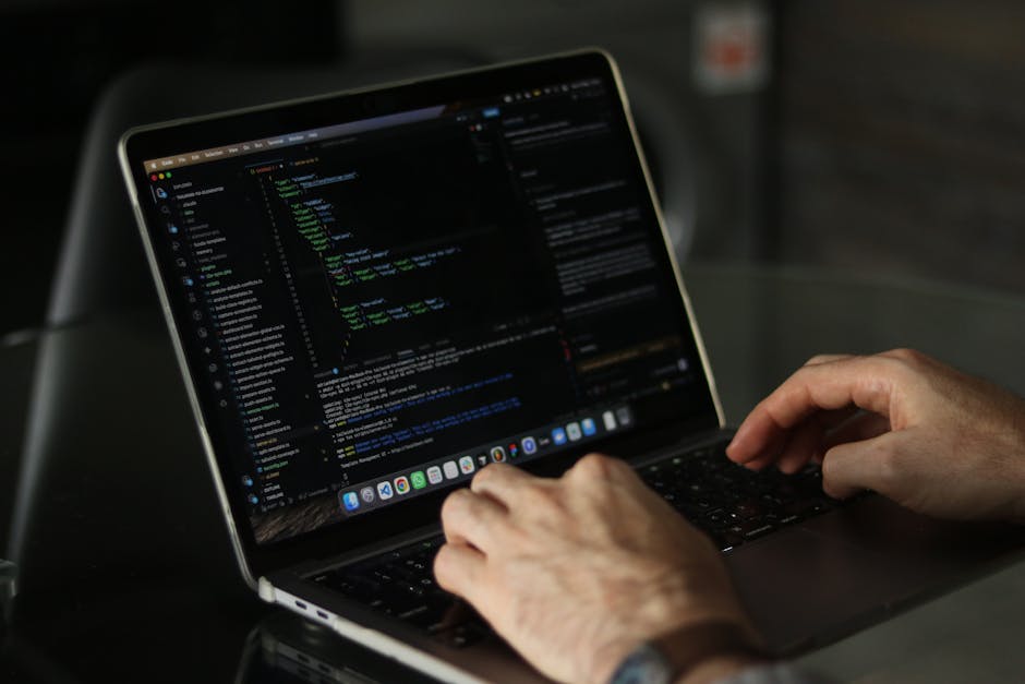 A close-up image of a computer screen displaying colorful lines of code, including HTML and CSS syntax, with various tags and attributes visible. The background is dark, and the code is highlighted in